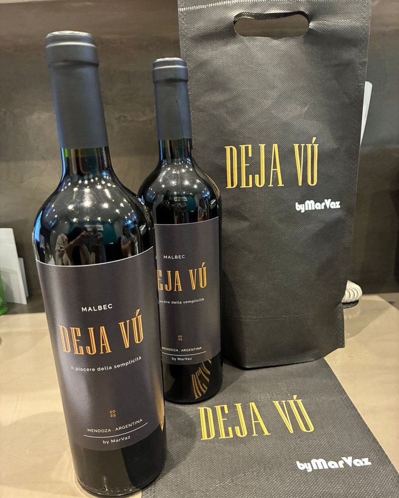 Dos botellas Deja V&uacute; junto a bolsas de presentacion de la marca